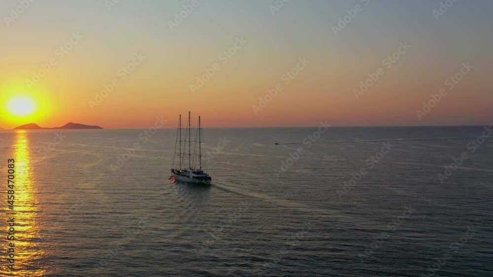 Aerial drone video of Cruise ship sails against a background of orange sunset Aerial drone video of Cruise ship sails against a background of orange sunset