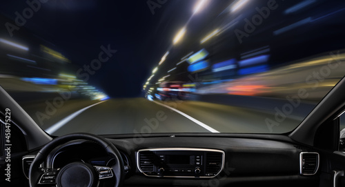 View from a car driving along a night city street.