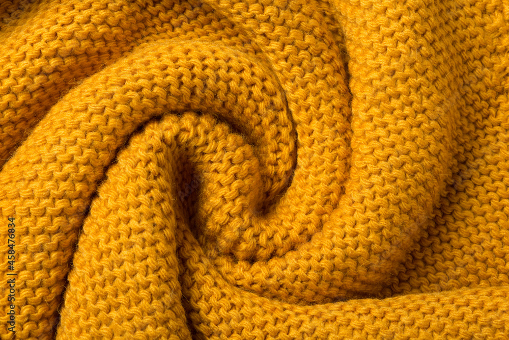 Fototapeta premium yellow knitted fabric twisted like a snail shell textured background