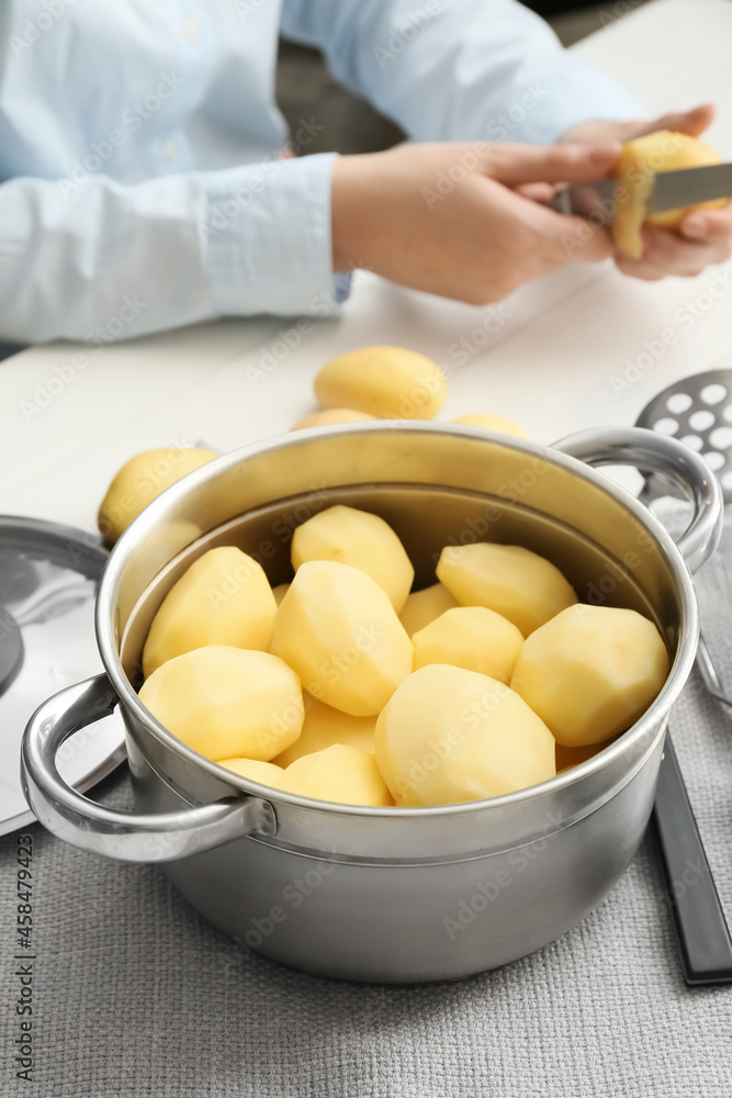 Woman preparing mashed potatoes at table in kitchen, closeup Woman preparing mashed potatoes at table in kitchen, closeup