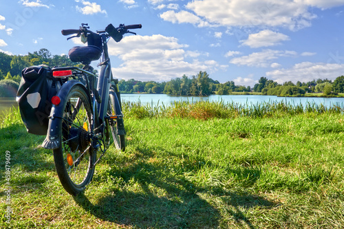 Photography Packed touring bike on a meadow in front of a pond during a bike tour through Ge