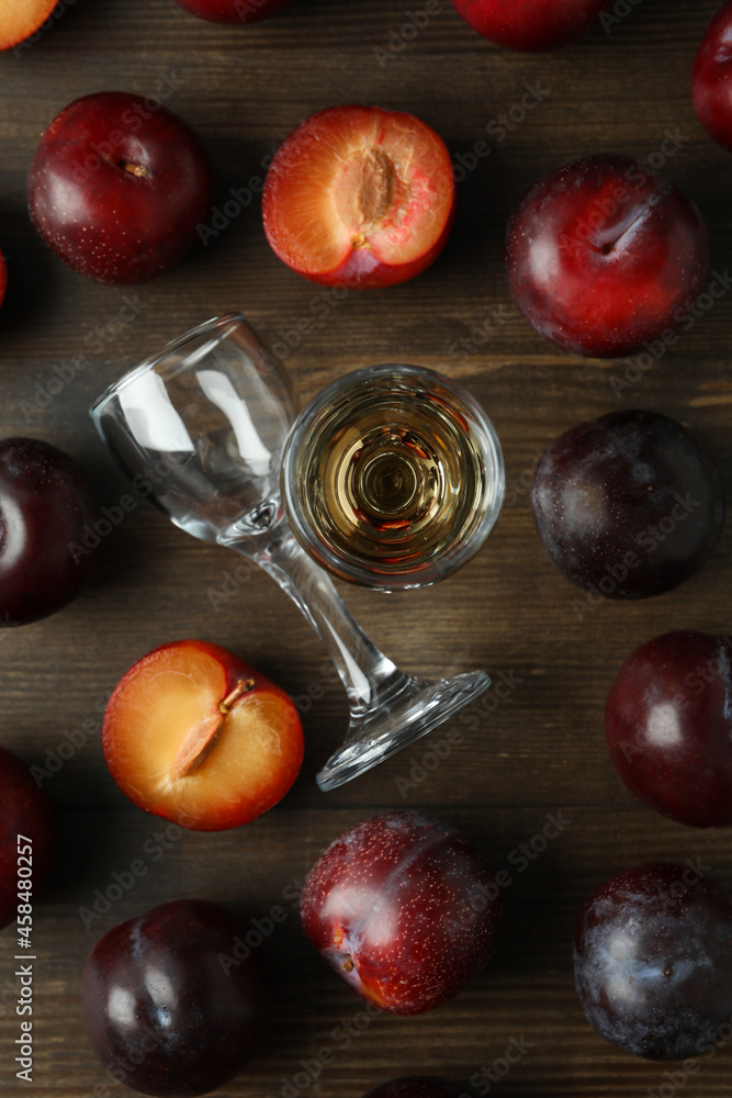 Plum vodka shot and ingredients on wooden table Plum vodka shot and ingredients on wooden table
