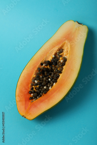 Half of ripe papaya on blue background