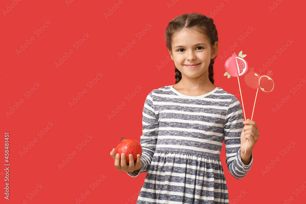 Little girl with pomegranate and decor for Rosh Hashanah (Jewish New Year) on color background Little girl with pomegranate and decor for Rosh Hashanah (Jewish New Year) on color background