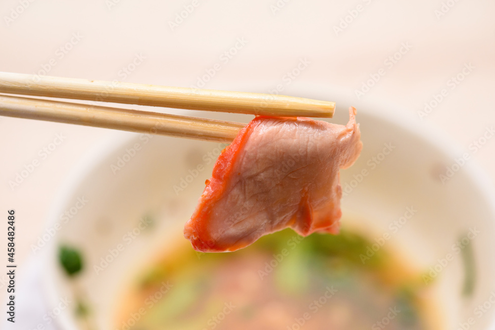 Pork chopsticks close up behind the bowl