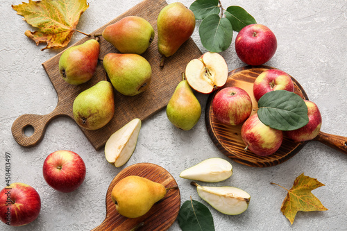 Fotografie Wooden boards with ripe pears and apples on light background