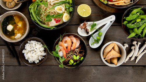 Asian dishes and snacks on wooden background.