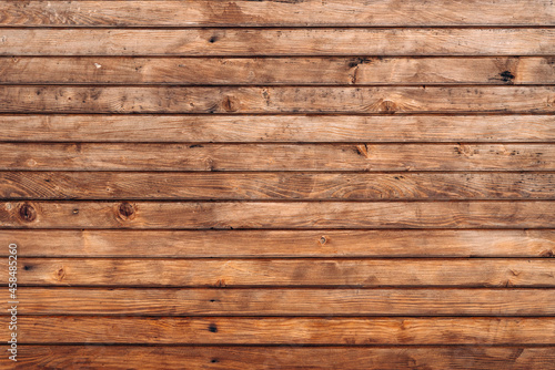 Reclaimed wood wall paneling texture. Wall of wooden fence. Winter wooden plank background, brown horizontal boards, wood texture. Stock photo