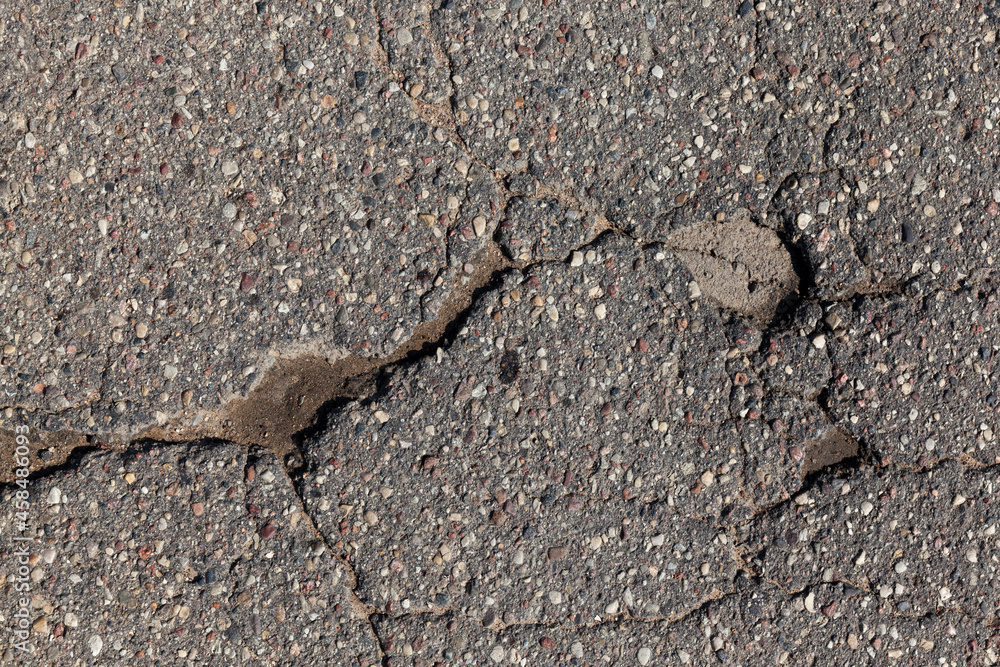 an asphalt road with a lot of holes and potholes an asphalt road with a lot of holes and potholes