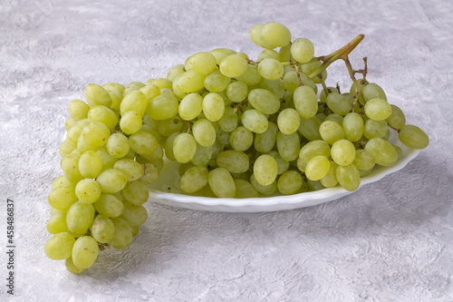 Bunch of white sweet grapes on a light background
