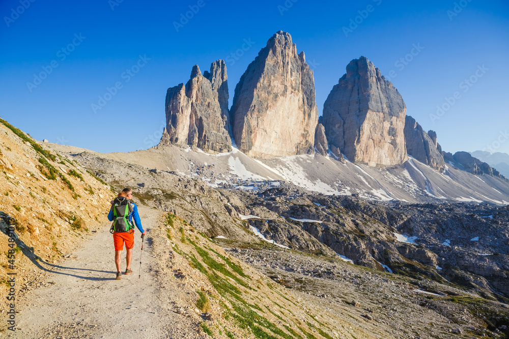 Young dad with baby boy travelling with backpack. Father on hiking adventure with child, family trip in mountains. Vacations journey with infant National Park Tre Cime di Lavaredo, Dolomites, Italy