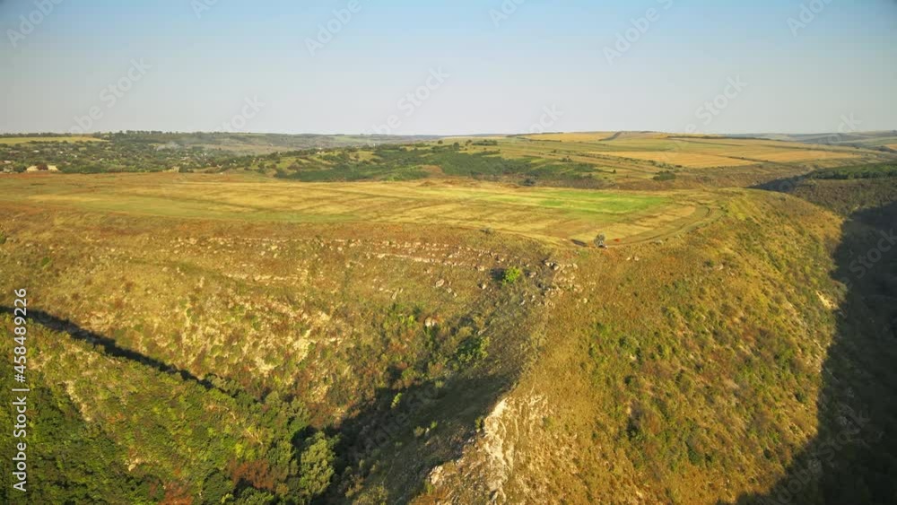 Aerial drone view of a valley with hill slopes covered with greenery, fields, village in Moldova Aerial drone view of a valley with hill slopes covered with greenery, fields, village in Moldova