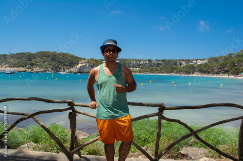 photo of a young boy on vacation in Menorca looking at the camera with the background of the sea and the beach, photo located in Balearic Islands, Spain © DarwinDSBNewYorkcity