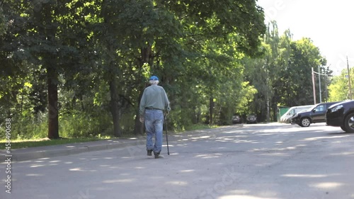 Wallpaper Mural An old man walks down the street in summer. Pensioner with a walking stick. Grandpa walks through a village in Russia. Torontodigital.ca