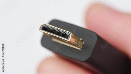 Close up of HDMI display monitor connector system or connection interface in hand isolated on white background. Display transfer information for digital camera gadget smartphone or laptop.