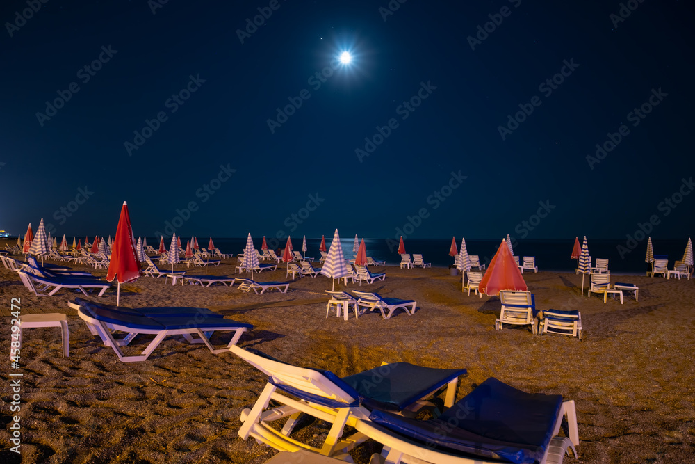Night beach, sand and sea views, umbrellas and sun loungers. Moon light. No body. coast and embankment Turkey Alanya. Copy space