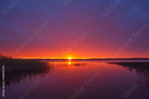 Red sunset over the lake with reflection in the water