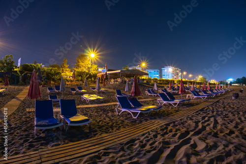 Night beach, sand and sea views, umbrellas and sun loungers. Moon light. No body. coast and embankment Turkey Alanya