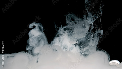 Meditative magic abstract background. White cloud of ink on a black background. © chekart