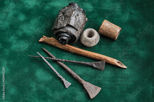 Ancient writing. Iron and bone stylos. Birch bark manuscript, clay spindle whorl, ancient bone product. photo