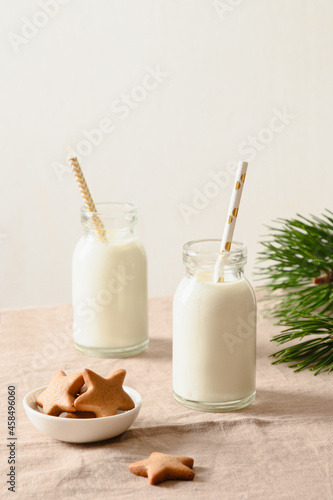 Homemade cookies and milk in two bottles for Santa Claus on Christmas table. Close up. Xmas holiday traditional treats.