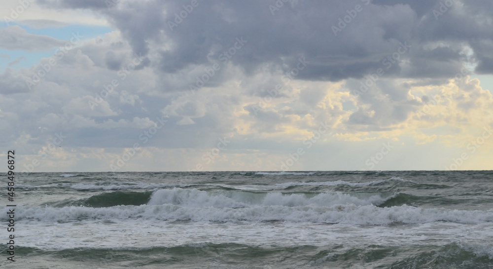 seascape: the sea during a storm, high waves rise, clouds hang over the water