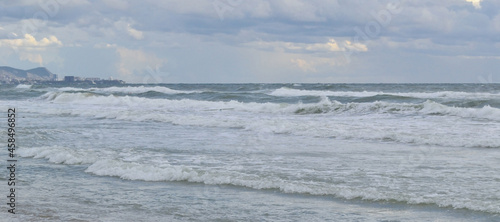 seascape: the sea during a storm, high waves rise, clouds hang over the water