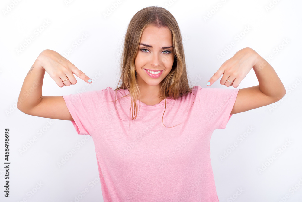 Pick me! Confident, self-assured and charismatic beautiful blonde girl wearing pink t-shirt on white background promoting oneself as wanting role smiling broadly and pointing at body. Pick me! Confident, self-assured and charismatic beautiful blonde girl wearing pink t-shirt on white background promoting oneself as wanting role smiling broadly and pointing at body.