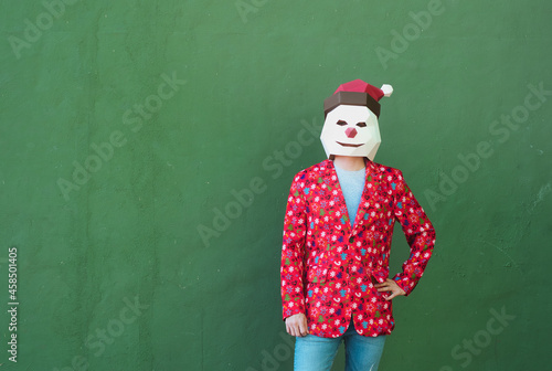 Anonymous person facing the camera while dressed in a christmas clothes and mask