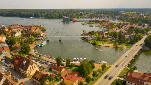 Beautiful panoramic aerial photo from drone to Mikolajki townscape - capital of Masurian region on the shore of the holiday resort beautiful summer afternoon. Mikolajki ,Mikołajki, Poland, Europe. photo