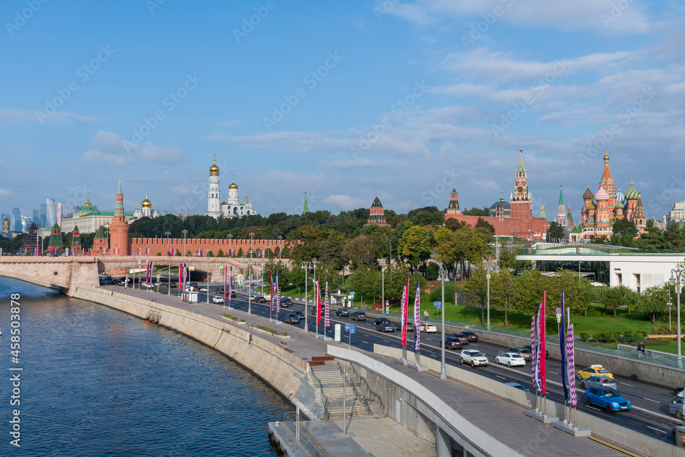 Cityscape of Moscow city downtown district. View of Moskvoretskaya embankment located by Moscow Kremlin, Red Square, St. Basil's Cathedral and Zaryadye park. Blurred cars on the road.