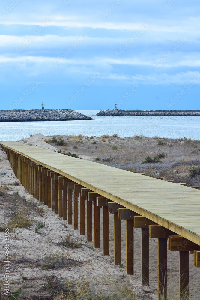 Wood beach walkway with two light houses in the background