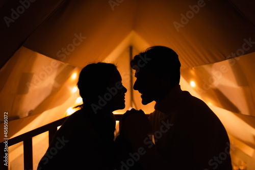 Side view of silhouette of couple in glamping house