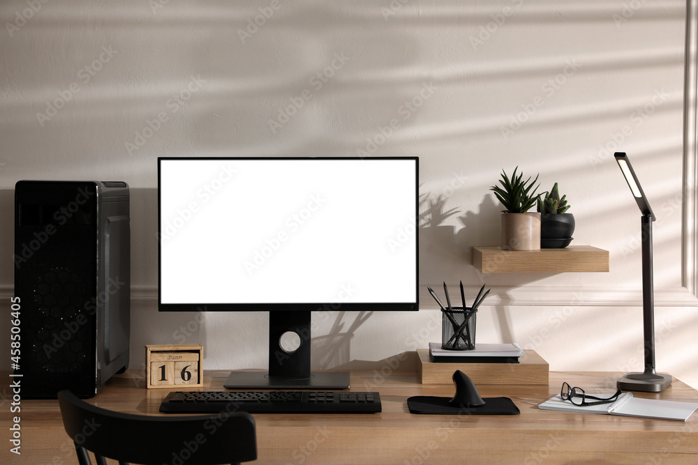 Stylish workplace with modern computer near white wall indoors. Space for text Stylish workplace with modern computer near white wall indoors. Space for text