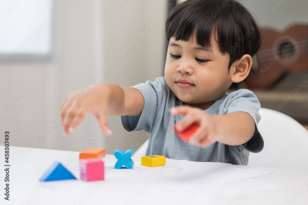 Asian little boy education from home. Developing children's learning before entering kindergarten Practice the skills of playing with wooden toys in living room. Asian little boy education from home. Developing children's learning before entering kindergarten Practice the skills of playing with wooden toys in living room.