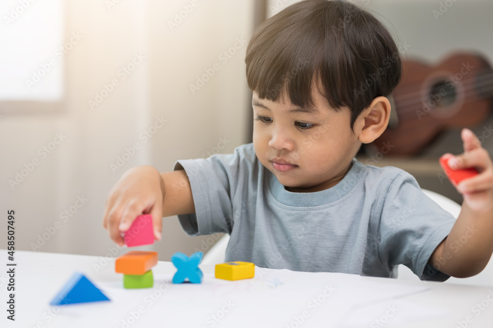 Asian little boy education from home. Developing children's learning before entering kindergarten Practice the skills of playing with wooden toys in living room. Asian little boy education from home. Developing children's learning before entering kindergarten Practice the skills of playing with wooden toys in living room.