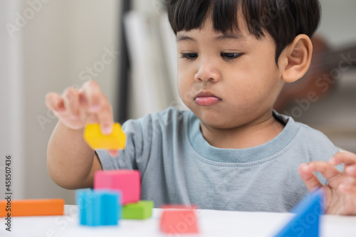 Asian little boy education from home. Developing children's learning before entering kindergarten Practice the skills of playing with wooden toys in living room.