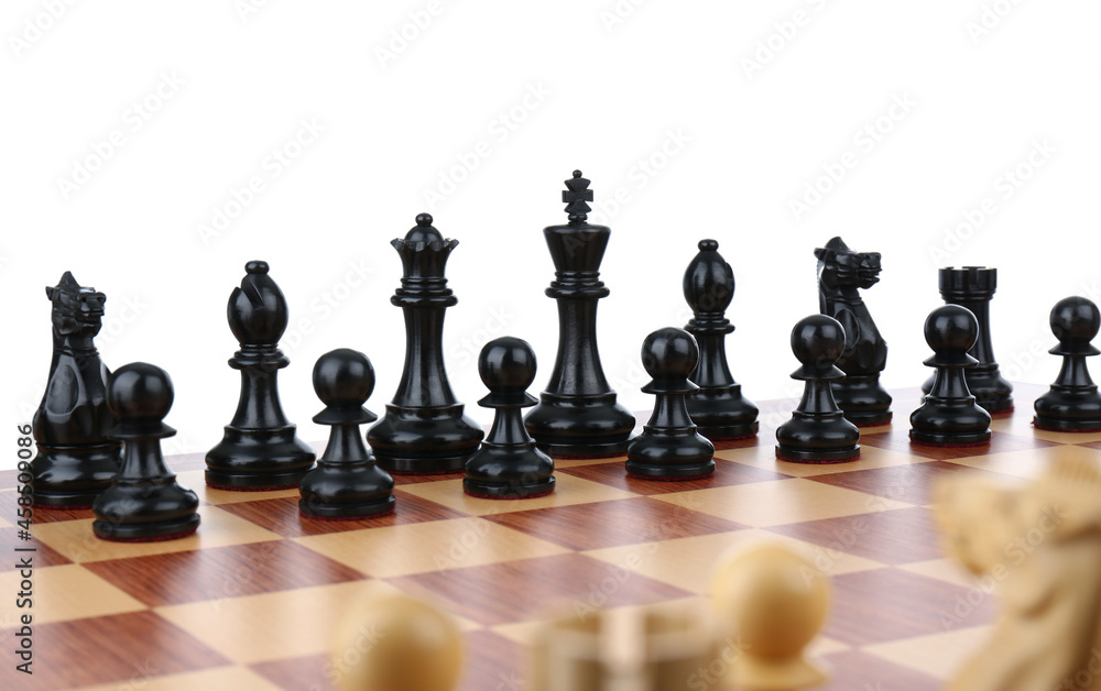 Set of black chess pieces on wooden board against white background Set of black chess pieces on wooden board against white background