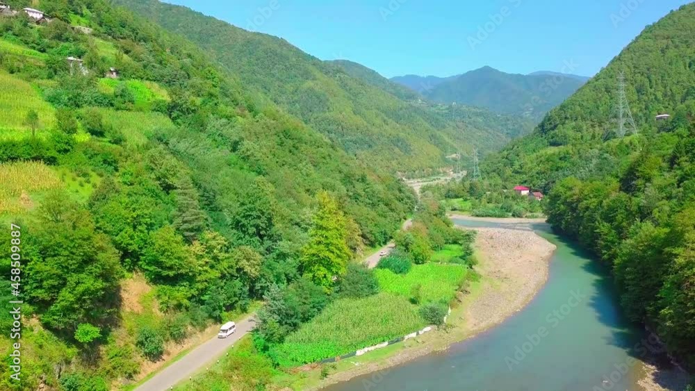 A bird's-eye view of a village in Georgia, located on the bank of the Chorokhi River, a canyon taken by a drone, a journey, a famous one. Summer, a sunny day. Cows graze, rafting on rafting. A bird's-eye view of a village in Georgia, located on the bank of the Chorokhi River, a canyon taken by a drone, a journey, a famous one. Summer, a sunny day. Cows graze, rafting on rafting.
