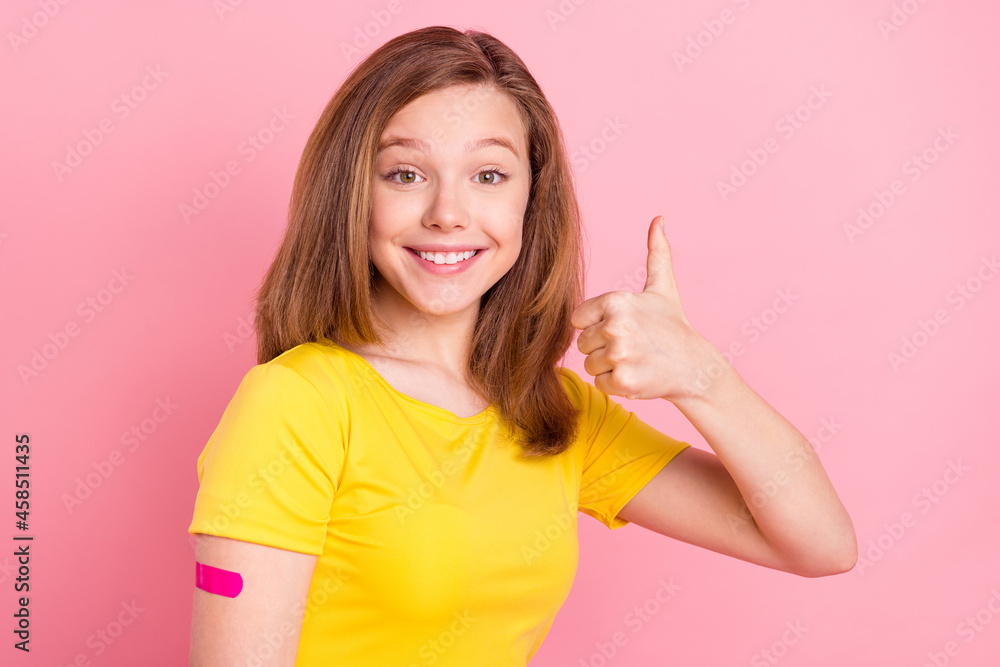 Profile side photo of young girl happy smile show thumb-up fine vaccination covid isolated over pink color background Profile side photo of young girl happy smile show thumb-up fine vaccination covid isolated over pink color background