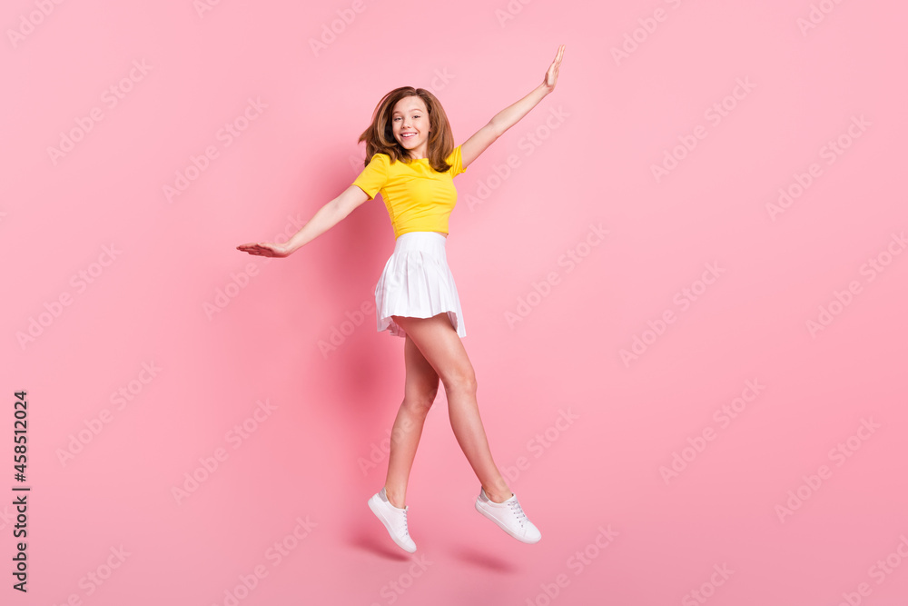 Full size profile side photo of young excited girl happy positive smile jump go walk isolated over pink color background Full size profile side photo of young excited girl happy positive smile jump go walk isolated over pink color background