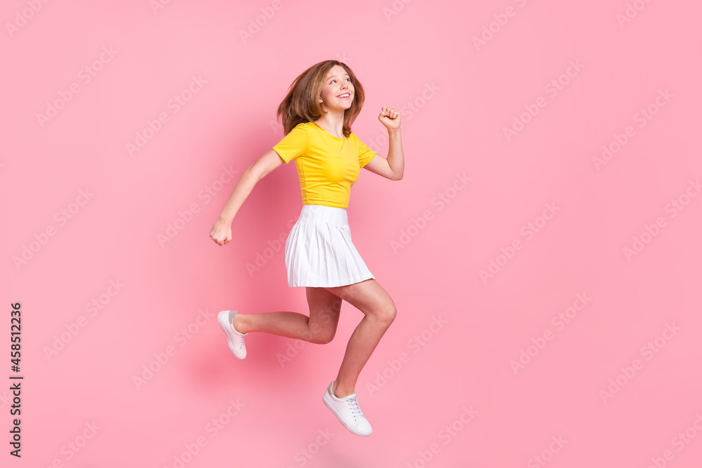 Full size profile side photo of young girl happy smile jump up go walk run isolated over pink color background
