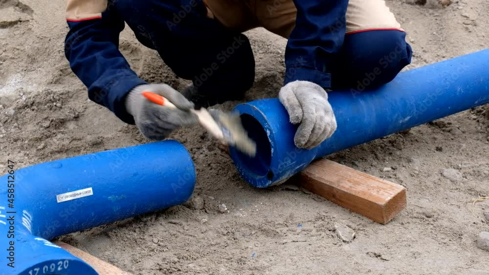 Worker cleans pipes for lubrication by brush Worker cleans pipes for lubrication by brush