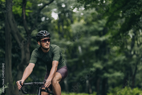 Healthy and fit man in helmet biking on fresh air