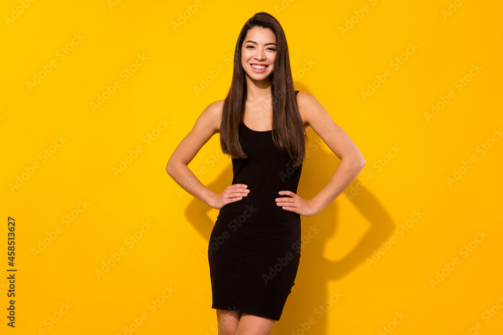 Photo of attractive young positive woman hold hands waist good mood isolated on yellow color background Photo of attractive young positive woman hold hands waist good mood isolated on yellow color background