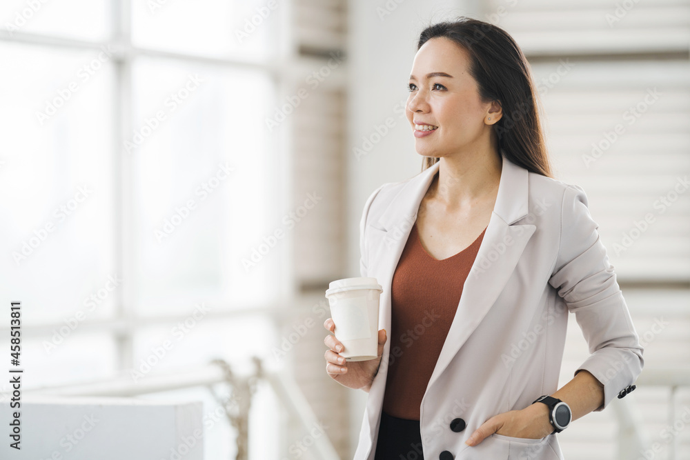 Businesswoman Holds Take Away Coffee Cup Stands in Company Building Businesswoman Holds Take Away Coffee Cup Stands in Company Building