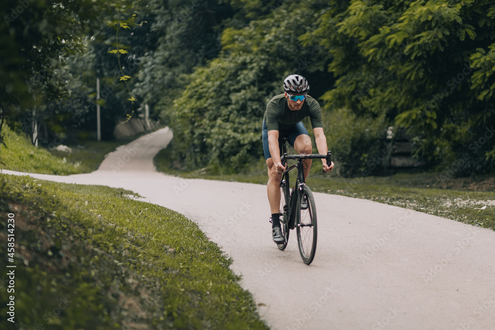 Fototapeta premium Caucasian man cycling at park during morning time