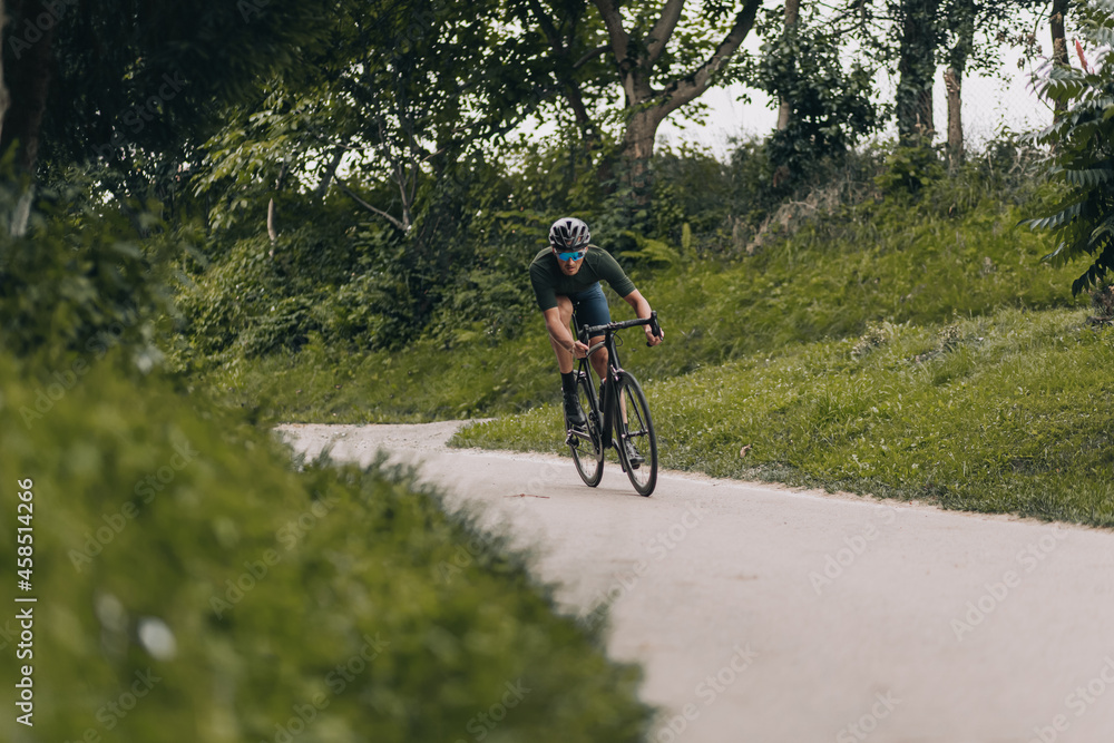 Strong caucasian man having active cycling at city park