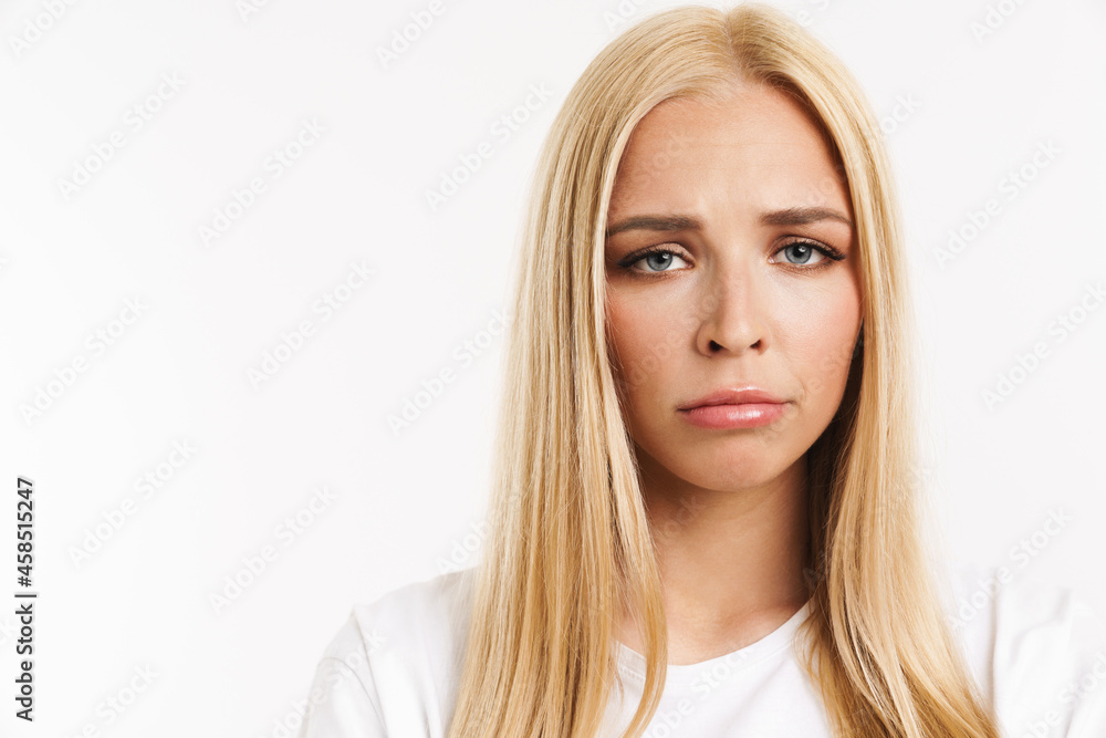 Young blonde woman in t-shirt frowning and looking at camera Young blonde woman in t-shirt frowning and looking at camera