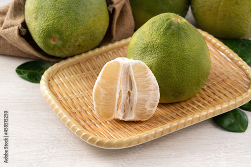 Fresh pomelo fruit on wooden table background.